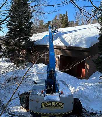 A crane removing snow off of a roof.