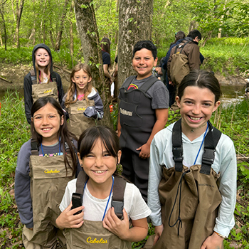 A group of students wearing waders for a Salmon in the Classroom program