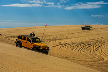 two ORV riding on sand dunes