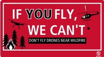 Placard showing a slogan "if you fly we can't" shows a drone and an aircraft about to collide over a wildfire.