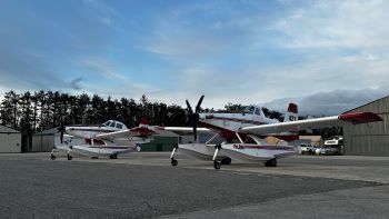 Two Fire Boss aircraft sit waiting to fly. The small white planes equipped with floats can scoop up to 800 gallons of water for firefighting.