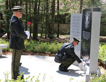 honor guard officers present roses to a memorial gravesite