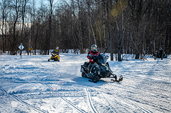 Snowmobilers are shown enjoying a Michigan trail ride.