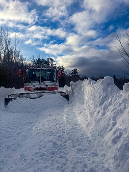 A trail groomer is shown confronting some deep snow on a trail in Keweenaw County.