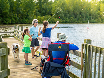 family of all ages fishing off pier