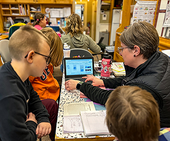 Sarah Roche from MiSTEM helps students create labels for lure packages.