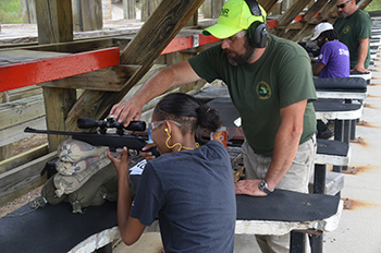 A DNR staff member assists someone at a DNR shooting range