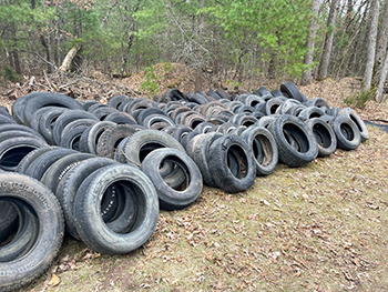 Piled-up tires that were discarded on public lands are shown. 