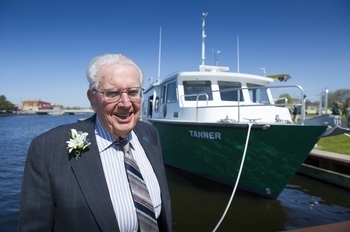 Dr. Howard Tanner stands in front of the RV Tanner during the christening ceremony for the Lake Huron research vessel in 2016.