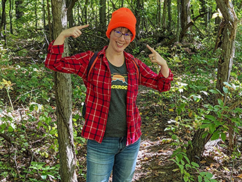 hiker pointing to her blaze orange hat