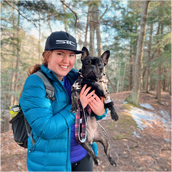 A woman hiking with her dog