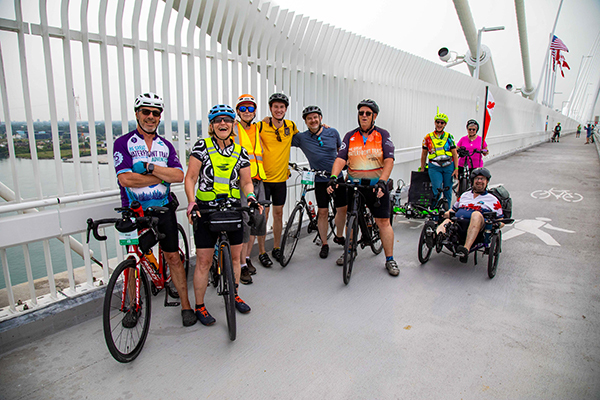 A group of riders pausing for a picture on the Gordie Howe Bridge during the 2026 Great Waterfront Trail Adventure. 