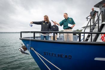 Department of Natural Resources Deputy Director Shannon Lot pours water over the bow of the RV Steelhead to christen it at the Sept. 30 ceremony.