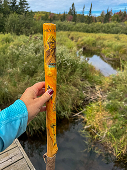 A hiker's walking stick with Smokey Bear on it is shown.