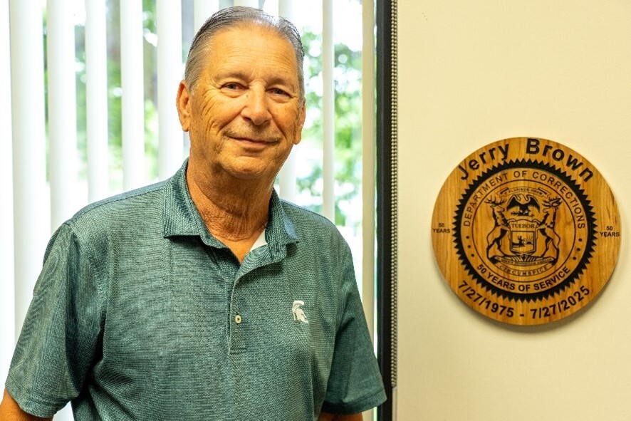 Supervisor Brown in his office with a plaque his colleagues presented him with
