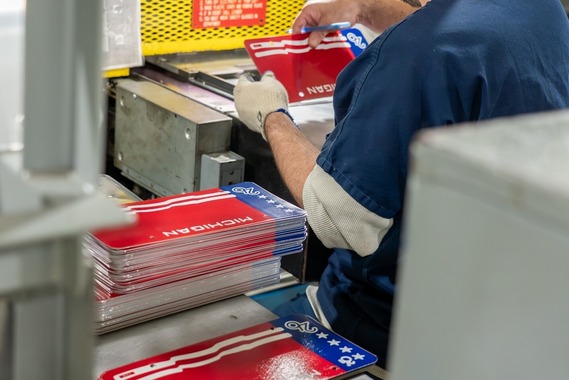 Prisoner stamping limited-edition license plates.
