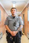 A corrections officer in a facility hallway