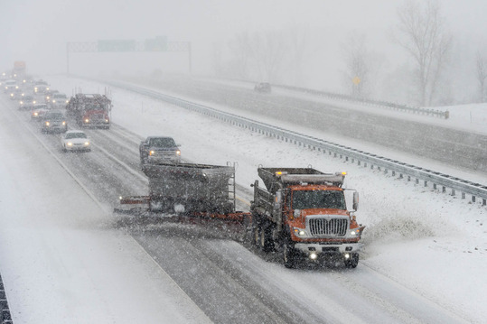 An MDOT snowplow clears snow and ice from a state freeway during a winter storm event.