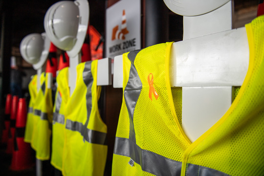 A memorial of worker vests and cones pay tribute to the road and bridge workers who lost their lives in a work zone crash.