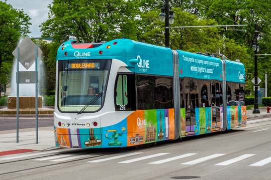 Qline train stopped at a pick up stop and crosswalk