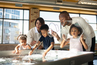 A family with children playing in a water children's exhibit.