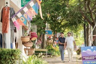 A couple holding hands outside shops in downtown Saugatuck