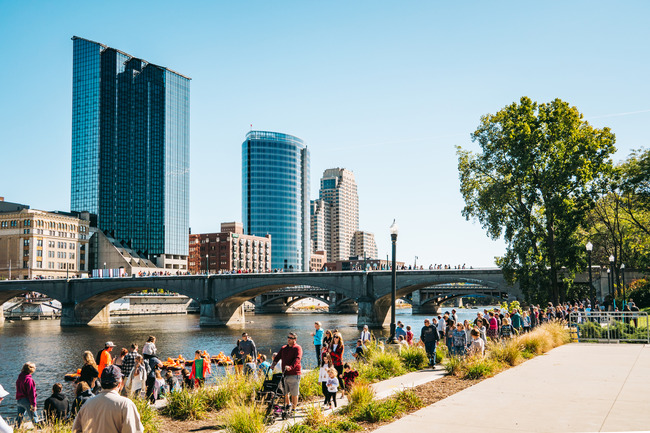 People walking along the Grand River in downtown Grand Rapids.