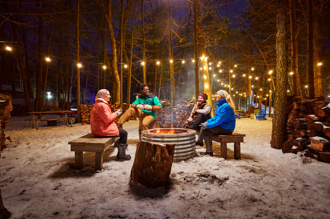 A group of friends around a campfire at the Muskegon Winter Sports Complex