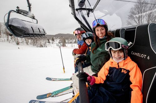 A family on a heated chair lift at a ski resort. 