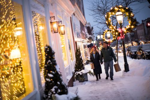 A couple walking past a holiday display in a shop window in downtown Petoskey.