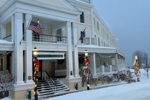 The exterior of a historic hotel decorated with holiday lights during winter. 