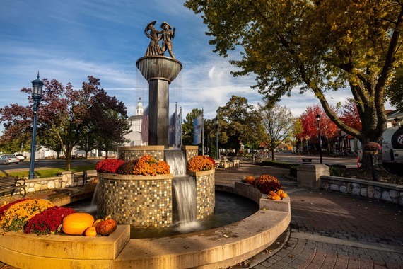 Outside fountain decorated with fall mums and pumpkins