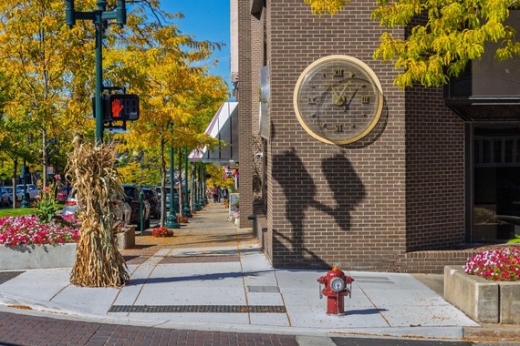 Downtown sidewalk with city clock and fall decorations