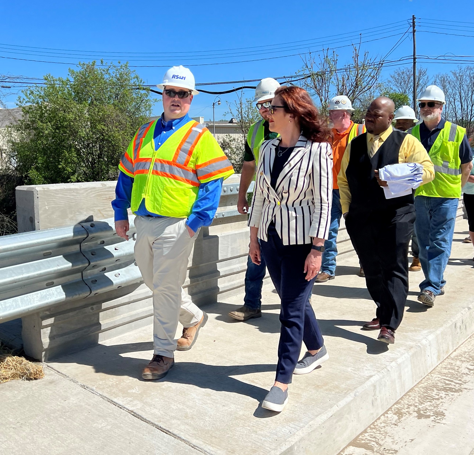 Gov. Whitmer speaks to MDOT works while they walk along the recently reopened bridge in Jackson 
