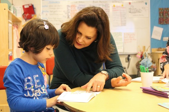 Governor Whitmer sitting with student working on a worksheet