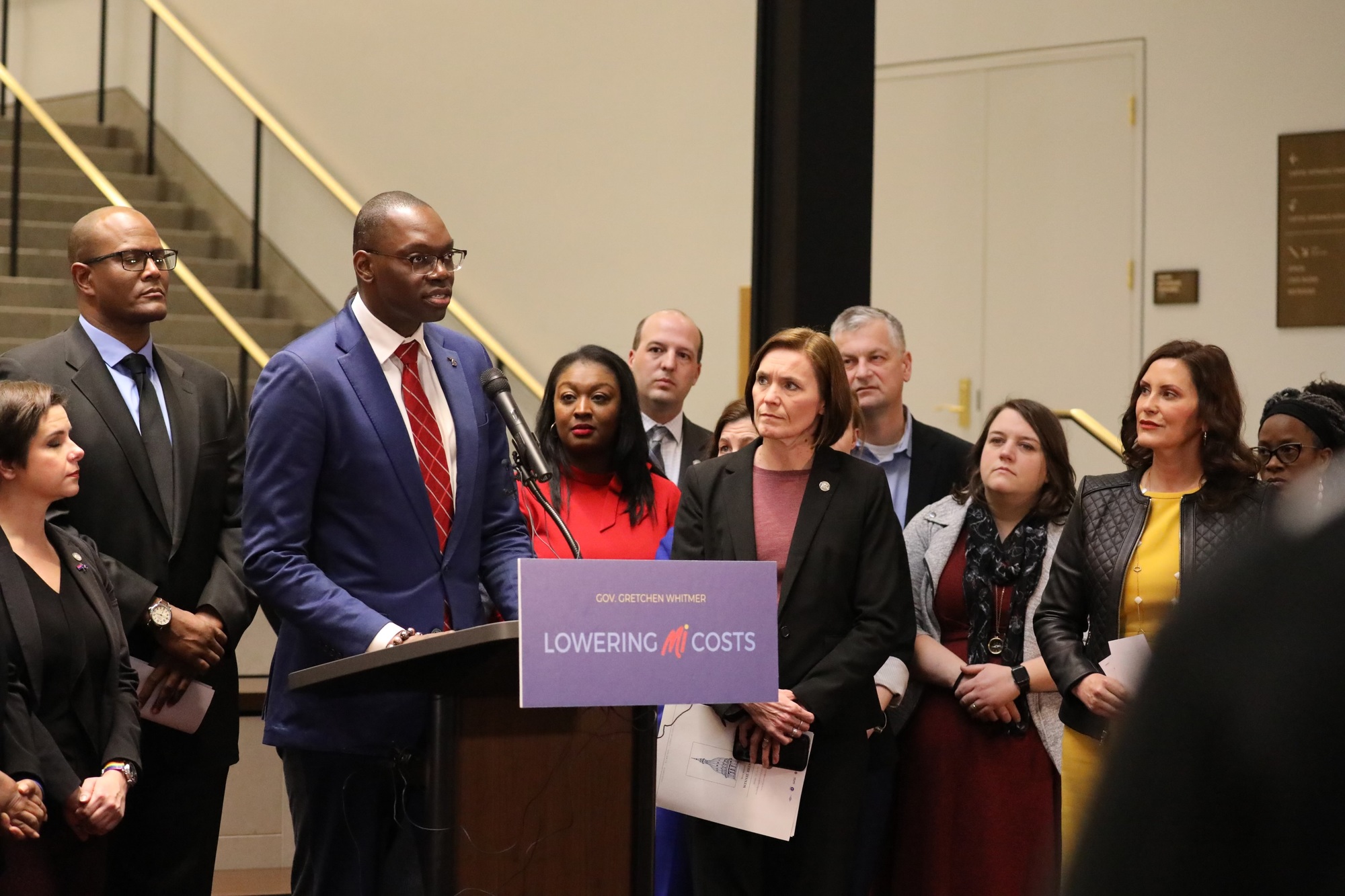 Lieutenant Governor Garlin Gilchrist II speaking at podium with a crowd of elected officials and Michiganders standing behind them