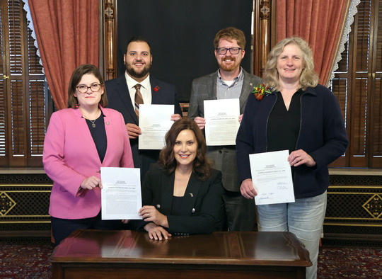 From left, standing, state Reps. Kara Hope (D-Holt), Alabas Farhat (D-Dearborn), Joey Andrews (D-St. Joseph) and Jenn Hill (D-Marquette) joined Gov. Whitmer for the signing of the final bill to ban child marriage in Michigan on Sept. 26, 2023.