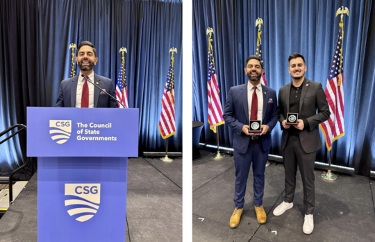 Rep. Puri stands with state Sen. Darrin Camilleri holding awards at a Council of State Governments conference.