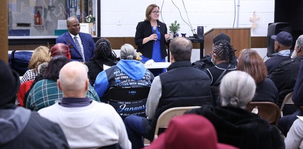 Rep. Price speaks to the crowd at a community conversation while Speaker Tate looks on.