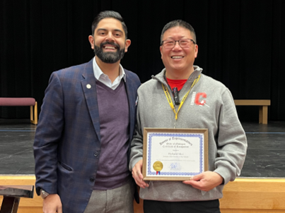 Rep. Puri stands with Teacher of the Month Mr. Richard Mui and his certificate of recognition.