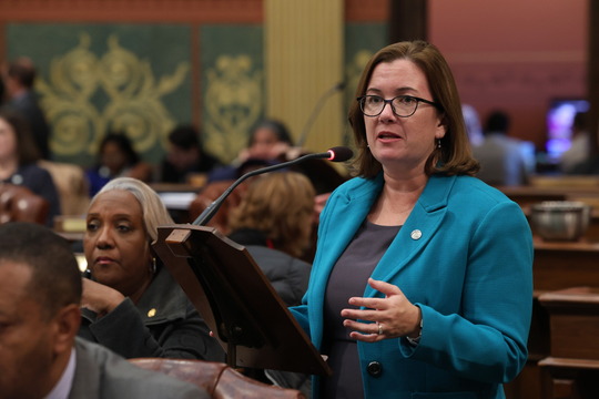 Rep. Price speaks at a podium on the Michigan House floor.