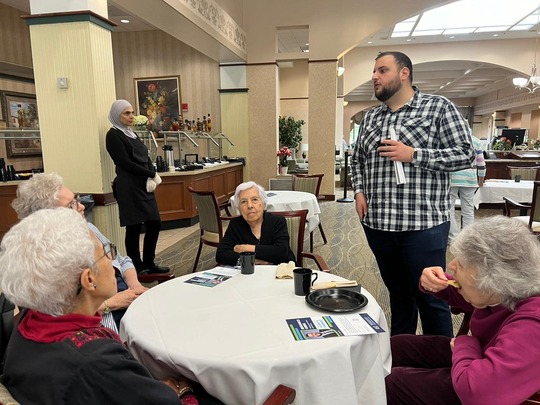 A photo of Rep. Farhat speaking to residents at a local senior center.
