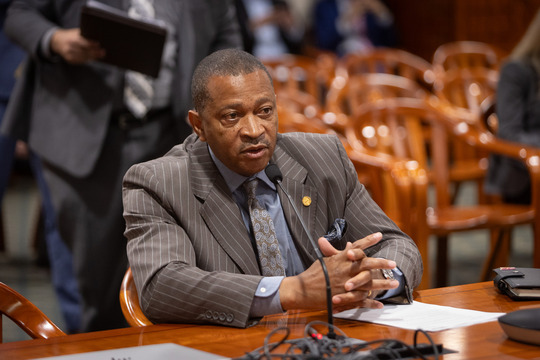 State Rep. Tyrone Carter, seated at the table in Committee.
