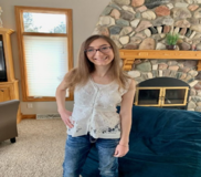 Alyssa G. standing with one hand on hip and smiling