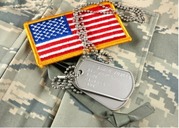 Dog tags and a patch of the American flag on top of army fatigues
