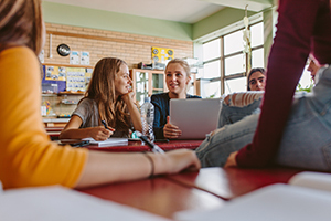 Group of students sitting around a table with some people off screen