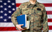 Close up of someone in Army fatigues holding books with the American flag in the background