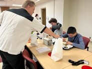 Teacher pouring something into the cup of a student