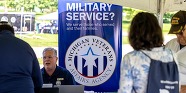 People at an outdoor event speaking to a Michigan Veterans Affairs Agency staff member 