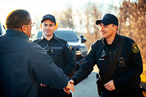 Police officer shaking hands with man